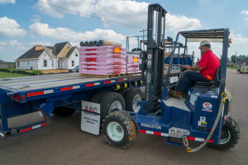 A man drives a fork lift for ABC Supply.