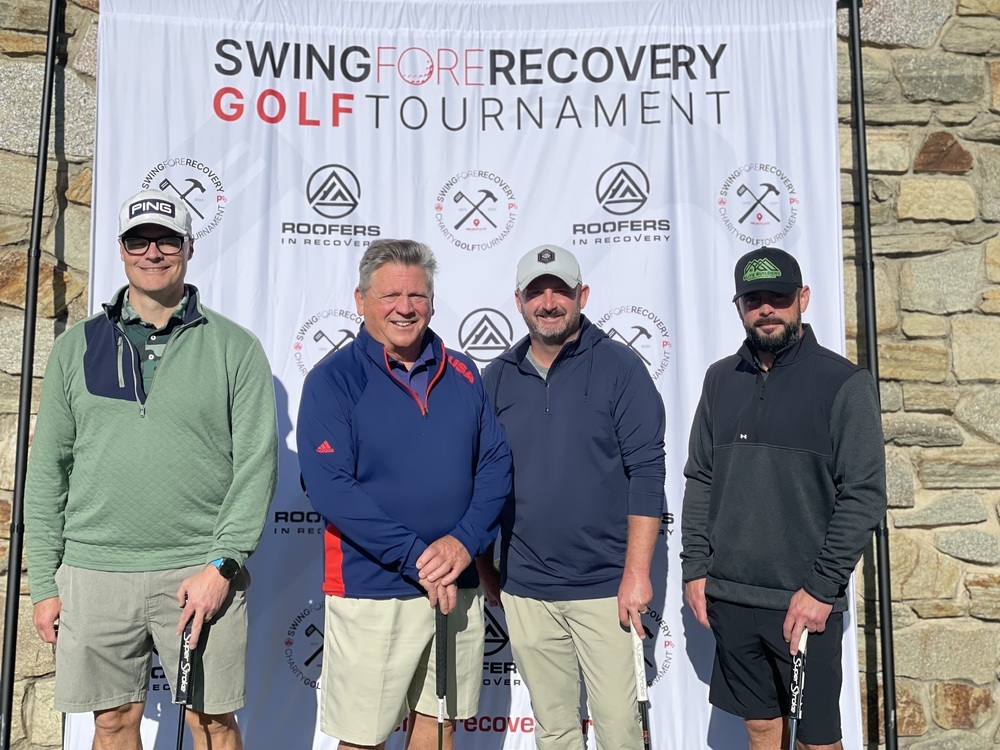 A team poses at the Swing Fore Recovery golf tournament for Roofers in Recovery.