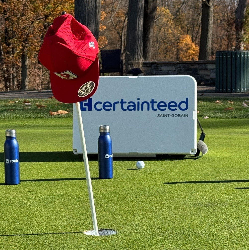 A hat rests on a golf hole flag at the Roofers in Recovery golf outing.