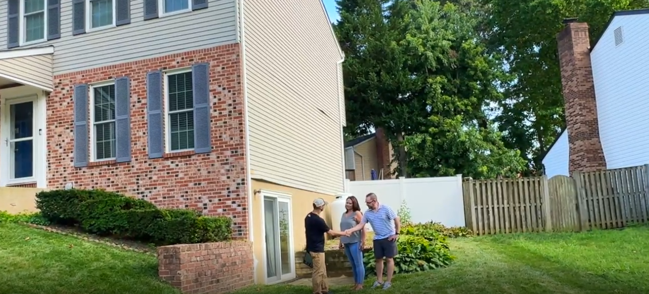 A roofing sales rep shaking hands with a homeowner